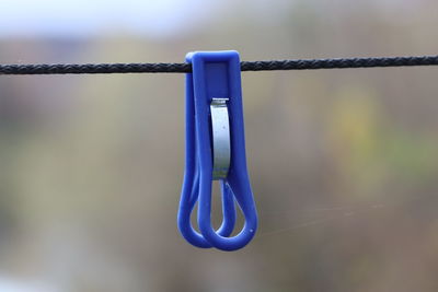 Close-up of clothespins hanging on rope
