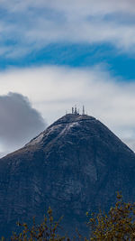 View of cross on mountain against cloudy sky