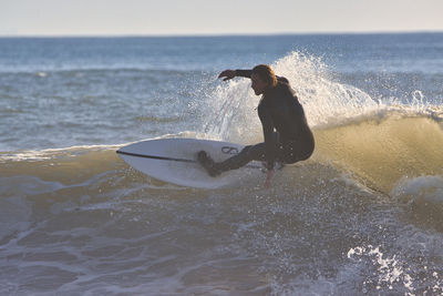 Man surfing in sea against sky