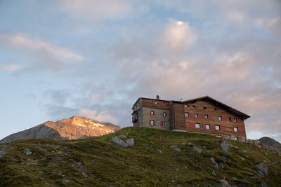 Low angle view of buildings on mountain against sky