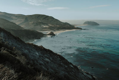 Scenic view of sea and mountains against sky