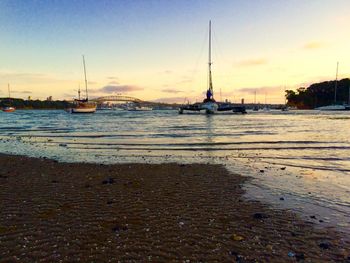 Boats in sea at sunset