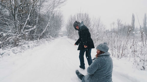 Family sledding in winter.  winter activity. happy, laughing, playful married couple is enjoying