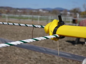 Close-up of yellow chain hanging on rope