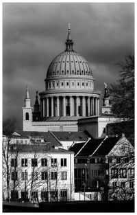 Buildings in city against cloudy sky