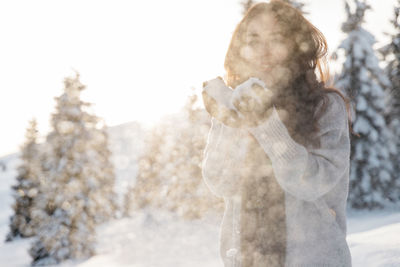 Rear view of woman holding snow