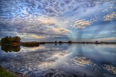 Scenic view of lake against sky at sunset