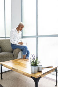 Casual businesswoman sitting in armchair writing in her journal