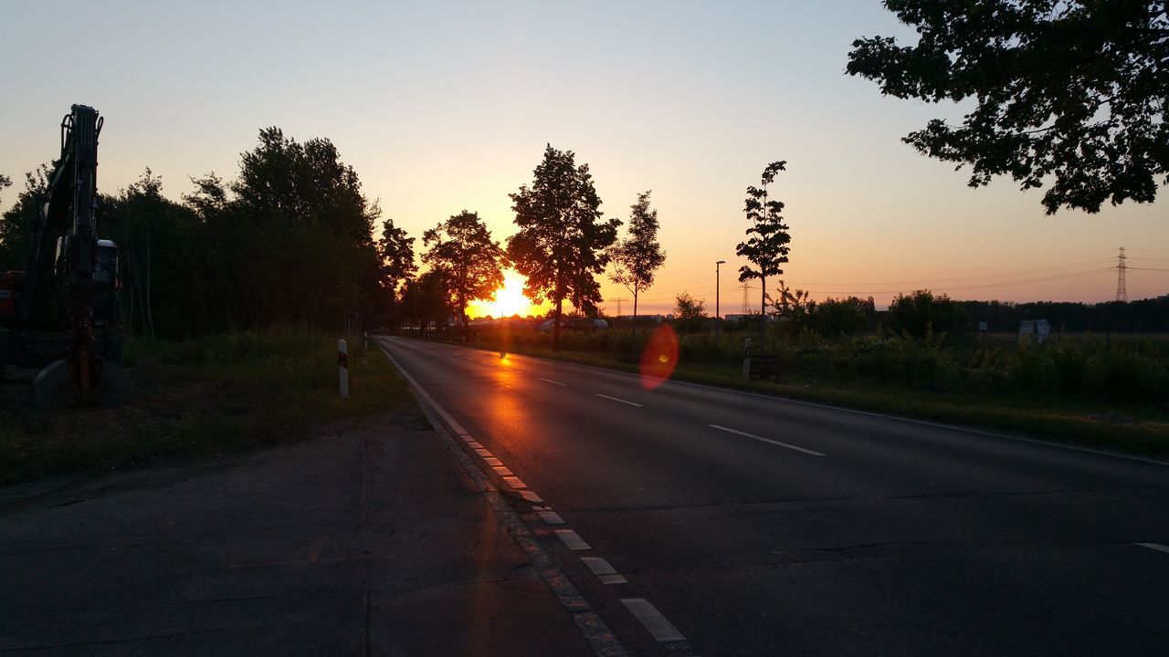 sunset, tree, road, the way forward, sun, street light, orange color, sunlight, sky, lens flare, tranquility, country road, diminishing perspective, nature, tranquil scene, empty road, vanishing point, landscape, empty, scenics, outdoors, sunbeam, no people, beauty in nature, illuminated, glowing, idyllic, non-urban scene