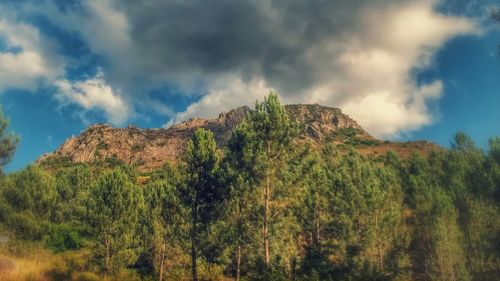 Low angle view of mountain against cloudy sky