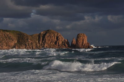 Scenic view of sea against and rock formations against sky