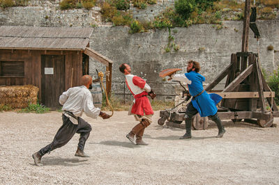 Rear view of people playing in front of building