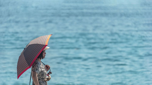 Woman with umbrella on the beach