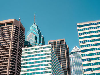 Low angle view of modern buildings against clear blue sky