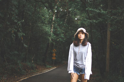 Portrait of teenage girl standing in forest