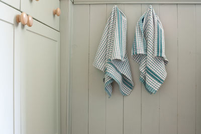 Dish towels hanging on wooden wall in kitchen at home