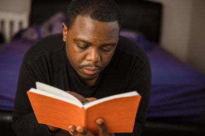 Portrait of young man reading book