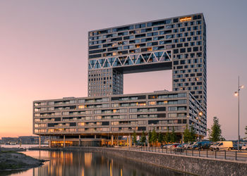 Reflection of buildings in city against clear sky