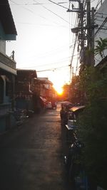 Road passing through city at sunset