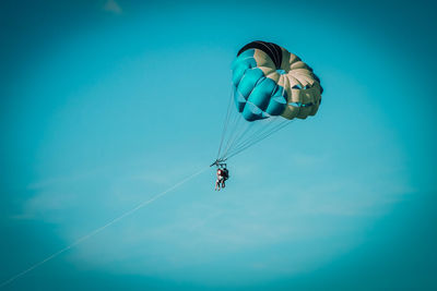 Low angle view of kite flying against blue sky