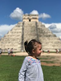 Girl standing against historic building