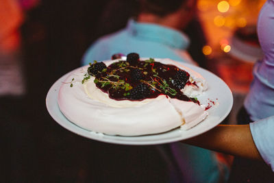 Midsection of person holding cake in plate