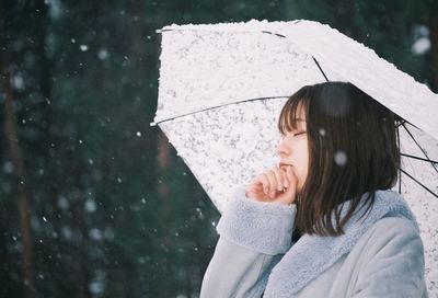 Portrait of woman with umbrella during winter