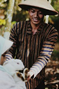 Smiling young man looking at girl with rabbit