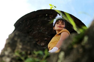 Low angle view of girl against sky