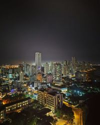 High angle view of illuminated buildings against sky at night