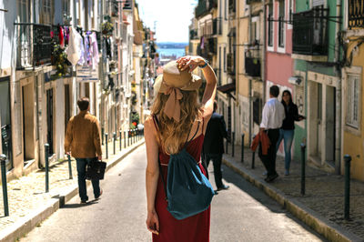 Rear view of woman standing against building