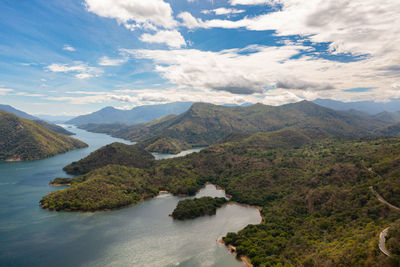 Aerial view of lake among the mountains against the blue sky and clouds. 