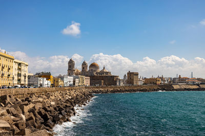 Buildings at waterfront against cloudy sky architecture cathedral seawall