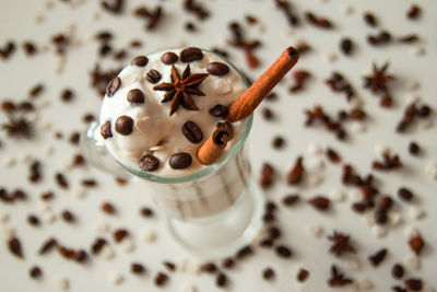 A glass of ice cream with coffee decorated of cinnamon sticks, coffee beans and star of anise. 