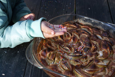 Child's hand with colorful decorations for a pie