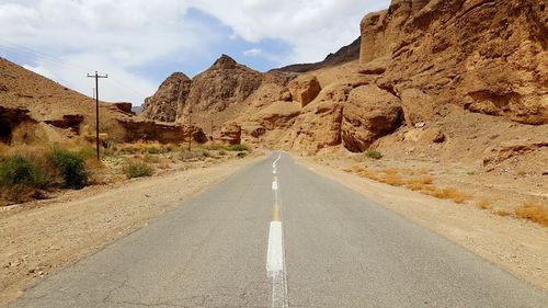 Road amidst rocks against sky