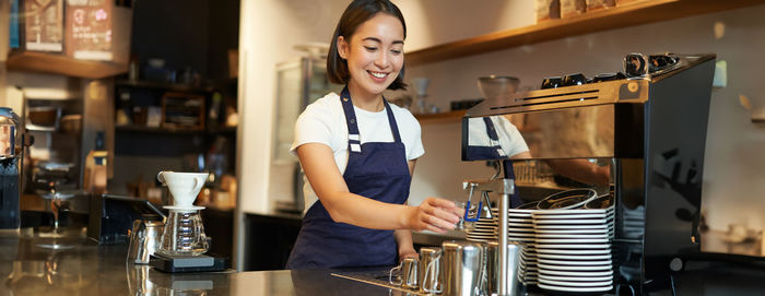 Portrait of young woman using mobile phone in cafe