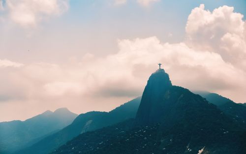 Silhouette of mountain range against cloudy sky