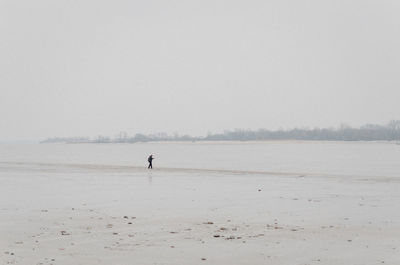 Silhouette man on beach against sky