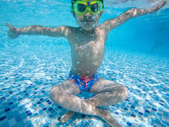 Portrait of shirtless boy swimming in pool