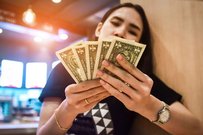 Close-up of young woman holding paper currencies on table