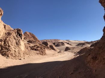 Scenic view of desert against clear blue sky