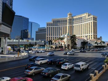 Traffic on city street by buildings against sky