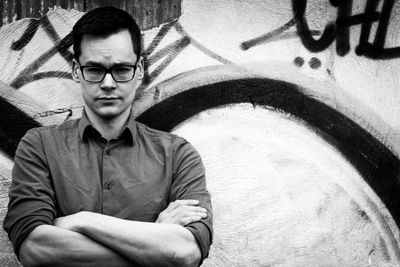 Portrait of confident man with arms crossed against wall