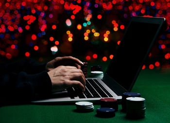 Midsection of man using mobile phone at table