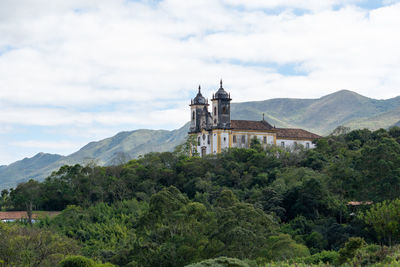 Historic building by mountains against sky