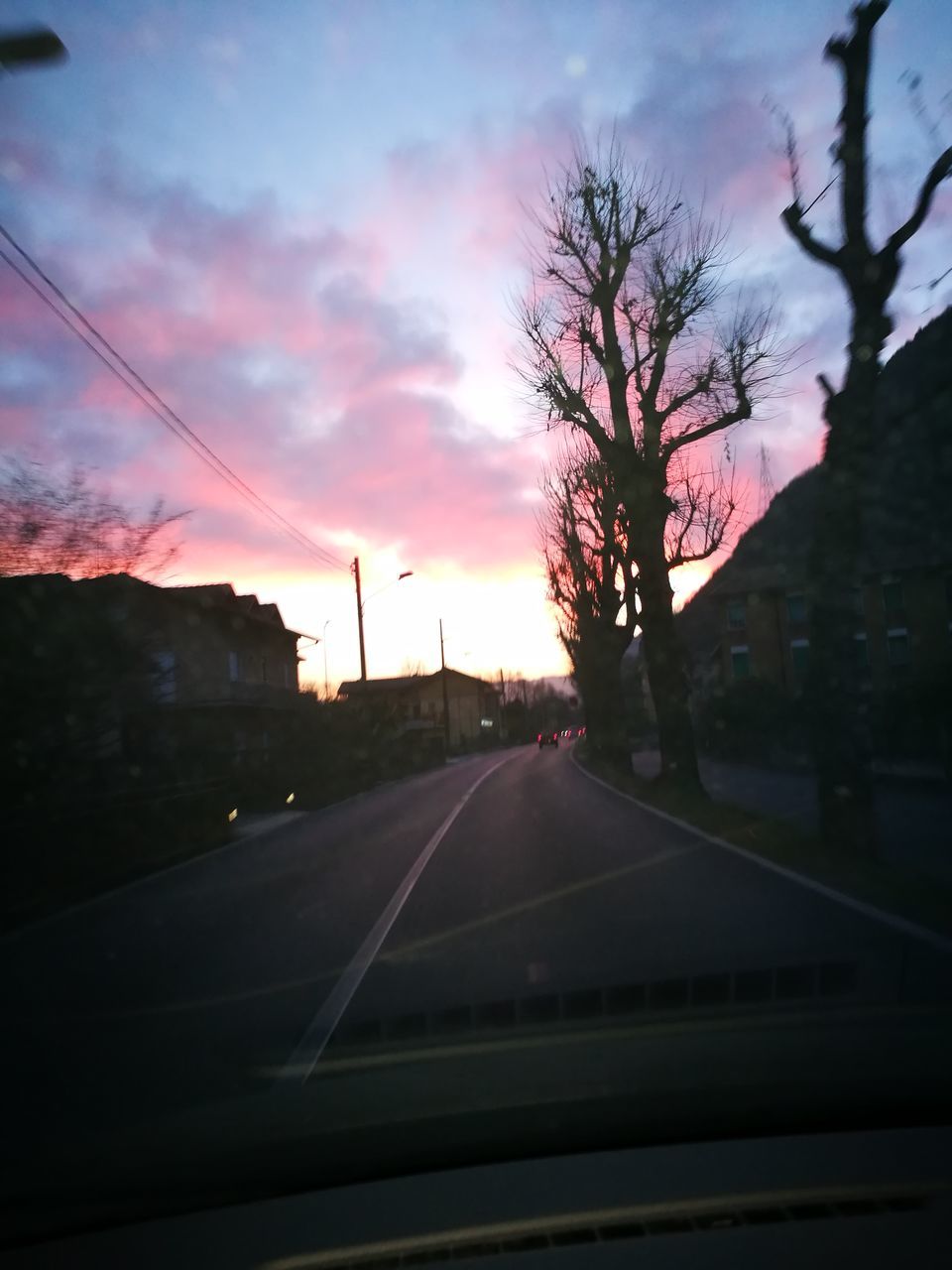 CAR ON ROAD AGAINST SKY DURING SUNSET