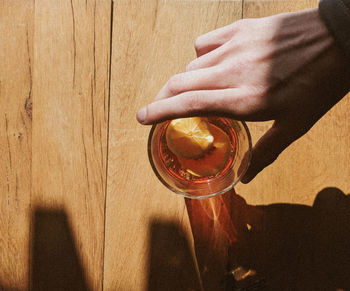 Close-up of hand holding glass of beer