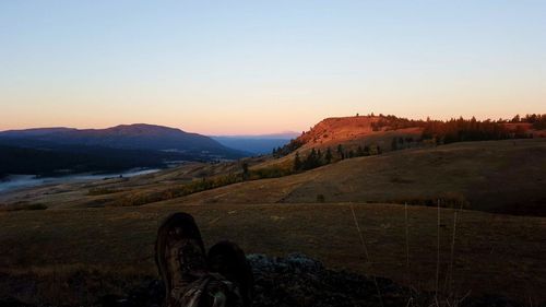 Scenic view of landscape against clear sky at sunset