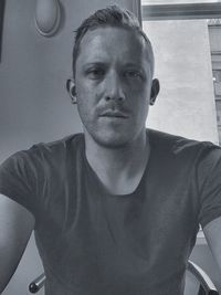 Portrait of young man standing against wall